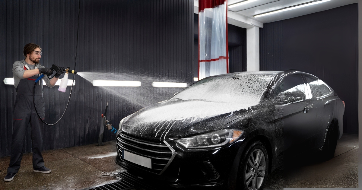 A professional providing car detailing service in a workshop.